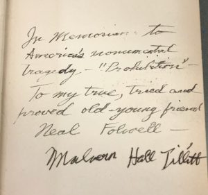 A photograph of the inside cover of a book with a handwritten note reading "In memorium to Americas monumental tragedy- "Prohibition"- To my true, tried, and proved old-young friend Neal Folcoell- Malvern Hall Tillett