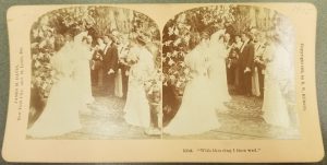 Wedding themed stereocard with a caption that reads "With this ring I thee wed"