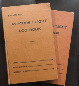 Two orange books with "Aviation Flight Log Book" on the cover