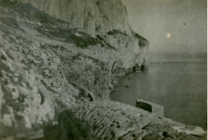 A black and white photograph of rocks and caves in a bay 