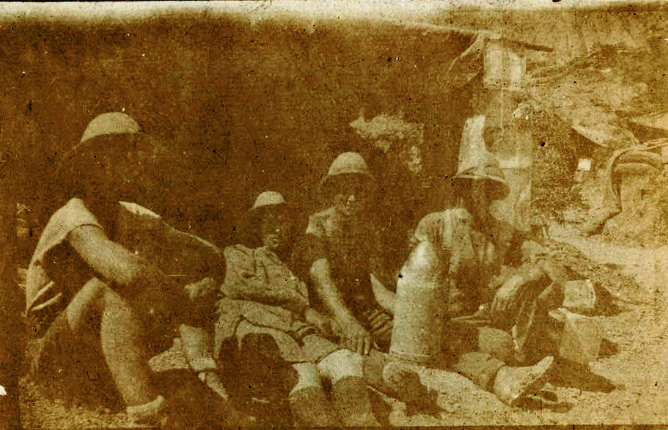 A grainy sepia photograph of four men in a trench during World War 1