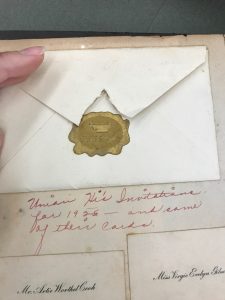 Envelope with gold decorative seal. Under the envelope is a cursive caption reading "Union HS Invitation from 1926 and some of their cards"