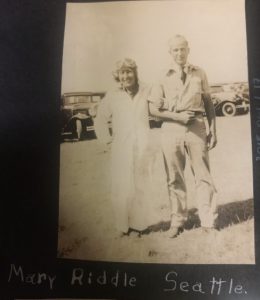 Black and white photograph of a man and women arm in arm with a caption that reads "Mary Riddle Seattle"