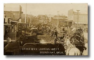 Black and White Photograph of Broadway Looking west in Drumright OK with horses and buggies on a dirt road