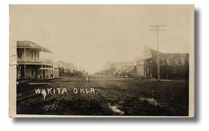 Black and White photograph of buildings facing a dirt road in Wakita OK