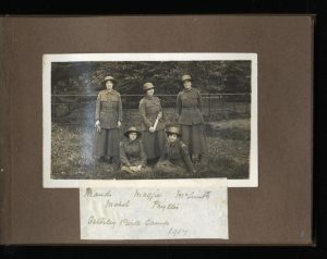 scanned image of a scrapbook page with photo of five women in WWI uniforms and a caption of their names below